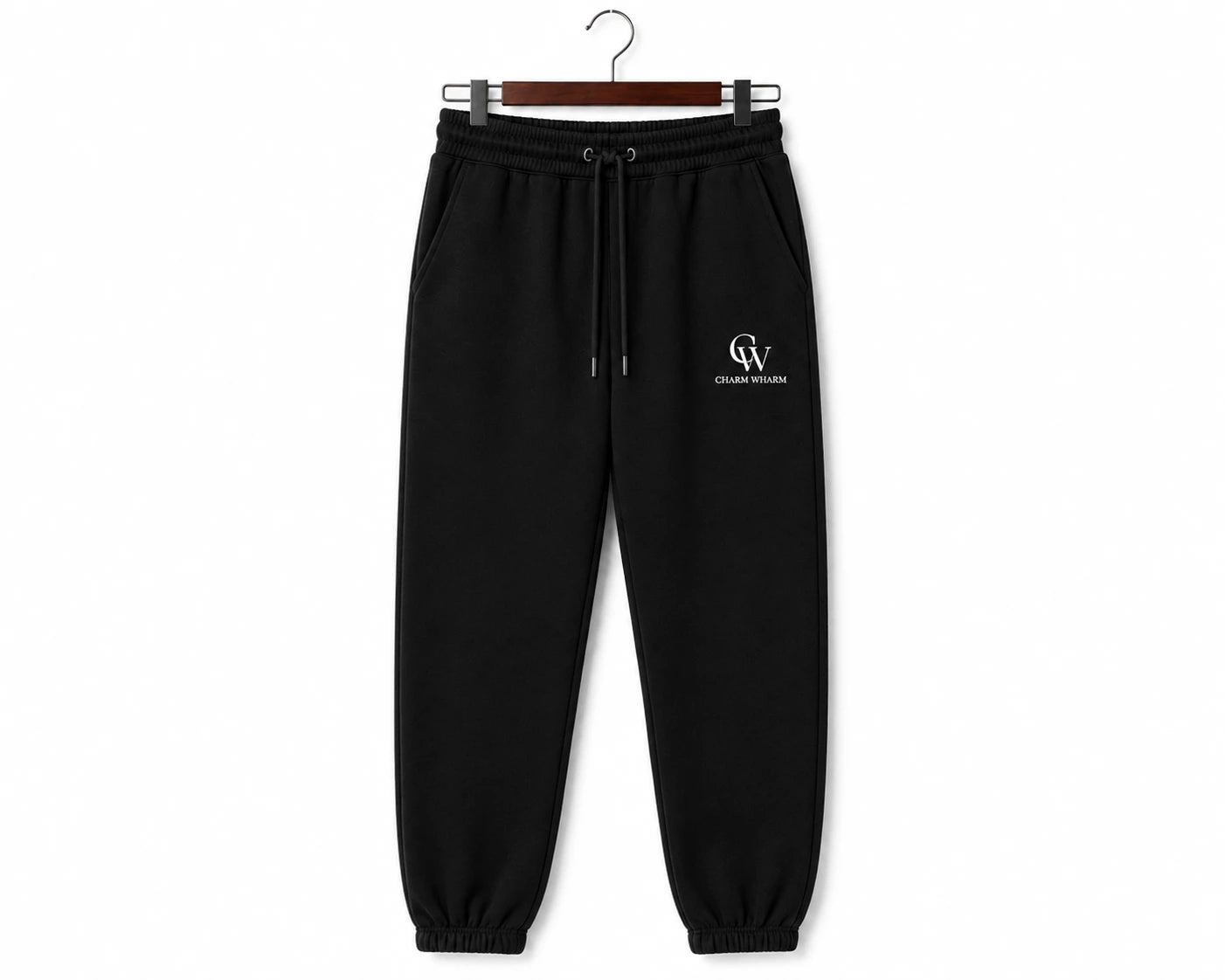 Black sweatpants with a drawstring waist and a small white 'CW' logo on the left thigh, hanging on a wooden hanger against a white background.
