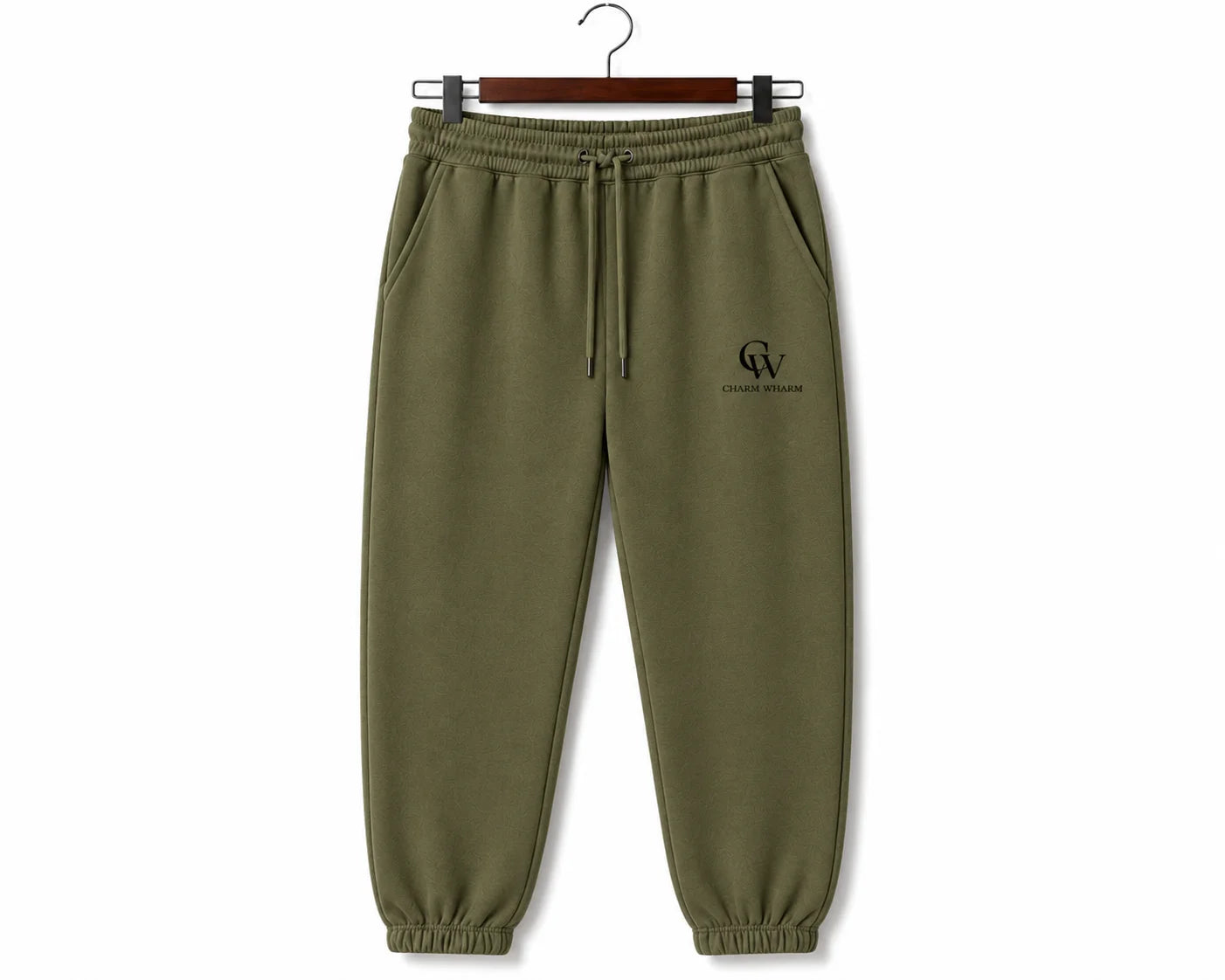 Olive green sweatpants with a drawstring waist and a small black embroidered logo on the left chest, hanging on a wooden hanger against a white background.